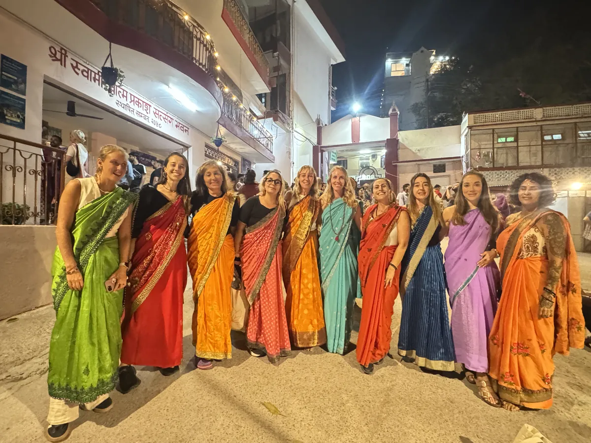 El grupo completo con saris de colores en una noche en Rishikesh